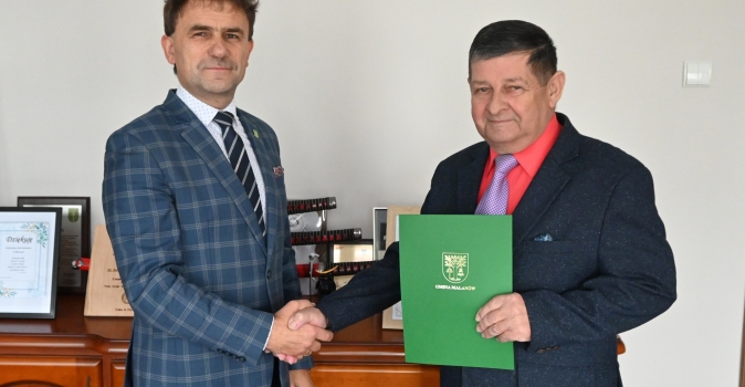 Dwóch mężczyzn z uściskiem dłoni i dokumentem